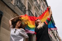 Casal lésbicas mulher com gay orgulho bandeira no o rua de madri cidade — Fotografia de Stock