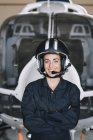 Ritratto di sorridente pilota di elicottero donna in hangar — Foto stock