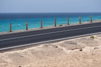Carretera y agua azul del océano en Canarias - foto de stock