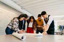 Office team working with blueprints — Stock Photo