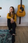 Jovem mulher bonita sentado e posando no chão na guitarra acústica — Fotografia de Stock