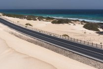 Road through desert and ocean water on Canary islands — Stock Photo