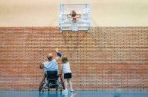 Behinderte Sportler und kleines Mädchen beim Basketball in der Halle in Aktion — Stockfoto