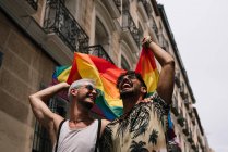 Пара мальчиков с флагом гей-гордости на улице Мадрида — стоковое фото