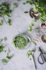 Handmade arugula pesto sauce in bowl on white marble counter — Stock Photo