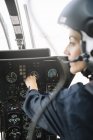 Fokussierte Pilotin, die im Hubschrauber sitzt und operiert — Stockfoto