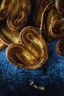 Pilha de biscoitos palmier em pilha no fundo azul gasto — Fotografia de Stock