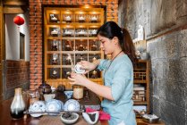 Junge Asiatin bereitet sich vor und braut orientalischen Tee — Stockfoto