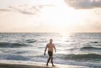 Сильний старий позує на пляжі — стокове фото