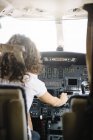 Уверенная брюнетка женщина, управляющая самолетом — стоковое фото