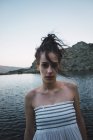 Портрет молодой женщины, стоящей рядом с волнистым озером — стоковое фото