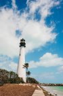View of white lighthouse standing on seashore on cloudy day in Miami — Stock Photo