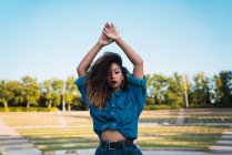 Молода жінка в джинсового одягу, стоячи в парку — стокове фото