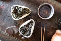 De dessus théière et feuilles de thé sèches sur la table orientale pour la cérémonie traditionnelle — Photo de stock