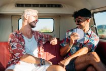Веселые мужчины играют в карты в фургоне — стоковое фото