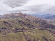 Pintoresca vista de drones de majestuosa cresta montañosa y terreno montañoso en día nublado en Asturias, España - foto de stock