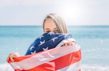 Дівчинка на пляжі з прапором США.. — стокове фото