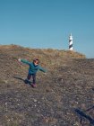 Веселый мальчик бежит на маяк — стоковое фото