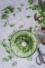 Handmade arugula pesto sauce in blander bowl on white marble counter — Stock Photo
