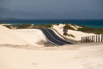 Дорога через пустелю і океанську воду на Канарських островах. — стокове фото