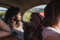 Mulher negra olhando através da janela enquanto viaja de carro — Fotografia de Stock