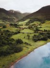 See und kleine Siedlung in grünen, malerischen Bergen — Stockfoto