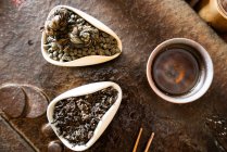 Da suddetta teiera e foglie di tè secche su tavolo orientale per cerimonia tradizionale — Foto stock