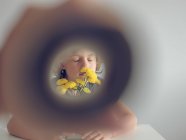 Niño y dientes de león a través de tubo de papel - foto de stock