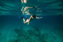 Garçon méconnaissable plongée avec tuba dans l'eau de mer — Photo de stock