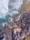 Удивительный вид на морскую воду, плещущуюся рядом с длинной скальной скалой в пасмурный день в Астурии, Испания — стоковое фото