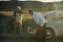 Men frustrated near a broken vintage car — Stock Photo