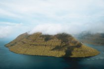Picturesque view to calm blue ocean and small green island, Feroe Islands — Stock Photo