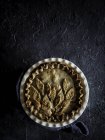 Appetizing fresh baked pie on dark rough background — Stock Photo