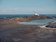 Felsige Küste und Leuchtturm — Stockfoto