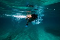 Unrecognizable boy snorkeling in dark sea — Stock Photo