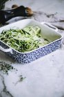 Grated zucchini for salad in patterned dish — Stock Photo