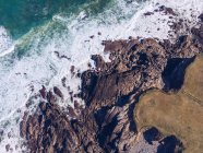 Von oben geschossen von Meerwasser, das in der Nähe der felsigen Küste in Asturien, Spanien, weht — Stockfoto
