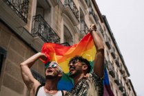 Пара мальчиков с флагом гей-гордости на улице Мадрида — стоковое фото