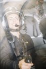 Sorridente pilota donna in casco seduto in elicottero — Foto stock