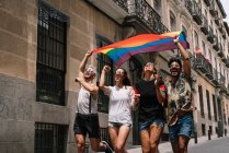 Gruppo di amici con una bandiera di orgoglio gay nella città di Madrid — Foto stock