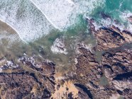 Сверху выстрел морской воды, машущей возле скалистого побережья в Астурии, Испания — стоковое фото