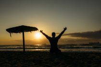 Homem velho forte posando na praia com as mãos para cima — Fotografia de Stock