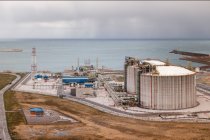 De cima vista do território da fábrica com edifícios e equipamentos colocados perto do mar azul — Fotografia de Stock