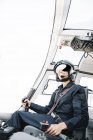 Lächelnde Pilotin sitzt im Hubschrauber und operiert — Stockfoto