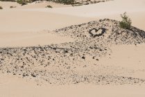 Pedras em forma de coração em planície arenosa nas ilhas Canárias — Fotografia de Stock