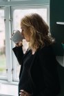 Крупним планом блондинка молода жінка п'є каву — стокове фото