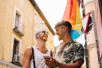 Pareja gay de chicos con Smatphone en la ciudad de Madrid - foto de stock