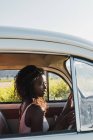 Bella sorridente donna africana americana guida auto — Foto stock