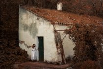 Giovane donna in abito bianco appoggiata al muro — Foto stock