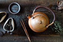 Сверху чайник и сухие чайные листья на восточном столе для традиционной церемонии — стоковое фото
